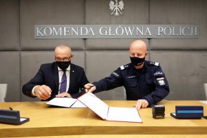 Gen. insp. Jarosław Szymczyk, p.o. Głównego Inspektora Ochrony Środowiska Marek Chibowski wymieniają się podpisanymi porozumieniami
