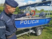 policjant stoi przy nowej policyjnej łodzi