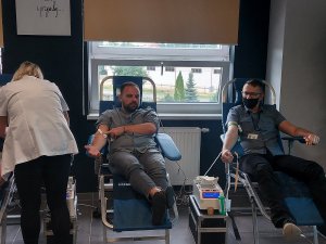 dwaj mężczyźni oddają krew podczas zbiórki w  sali konferencyjnej w Komendzie Powiatowej Policji w Opocznie