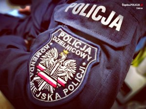 naszywka na ramieniu munduru policjanta z napisem Policja Dzielnicowy Komenda Miejska Policji