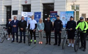 Czterech policjantów z rowerami stojących wspólnie z komendantem wojewódzkim inspektorem Waldemarem Wołowiec oraz samorządowcami.