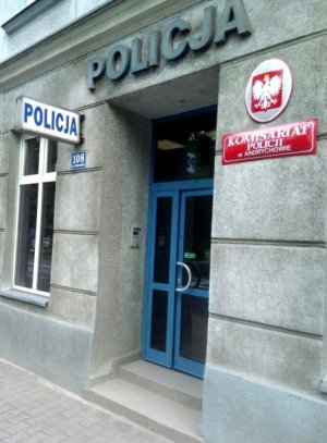 Ściana budynku i drzwi wejściowe do komisariatu. Nad nimi napis Policja po prawej stronie Godło Polski i napis Komisariat Policji w Andrychowie