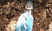 zniszczona zabytkowa figurka Matki Boskiej leży w liściach