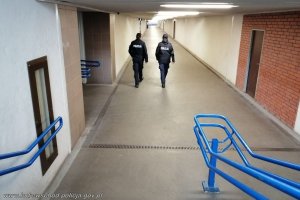 patrol dwóch umundurowanych policjantów idzie korytarzem dworca kolejowego