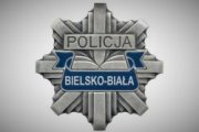 Policyjna odznaka z szarym napisem Policja i białym napisem na granatowym tle Bielsko Biała