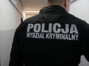 widok na plecy mężczyzny, na których na kurtce widać biały napis Policja, Wydział Kryminalny