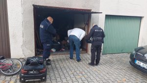 Przeszukanie budynku murowanego garażu przez dwóch umundurowanych policjantów polskiego i czeskiego