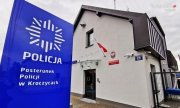 Na zdjęciu widoczny budynek Posterunku Policji w Kroczycach, przed którym znajduje się panel informacyjny. Na niebieskim tle, znaduje się biała gwiazda policyjna i napis Policja, a poniżej napis: Posterunek Policji w Kroczycach