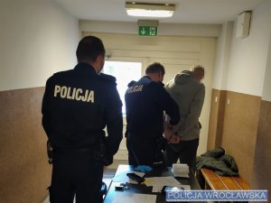 policjanci sprawdzają zatrzymanego mężczyznę