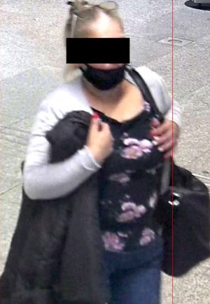kobieta na jednym ramieniu ma zawieszoną torebkę, a pod drugim trzyma kurtkę