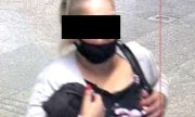kobieta w maseczce na twarzy na jednym ramieniu ma zawieszoną torebkę, a pod drugim trzyma kurtkę