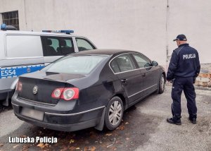 policjant stoi obok pojazdu marki Volkswagen