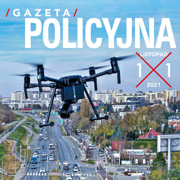 Fragment okładki Gazety Policyjnej przedstawiający drona w locie nad miejską ulicą.
