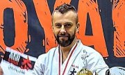 policjant w kimono odbierający nagrodę za zdobycie wicemistrzostwa Polski w karate