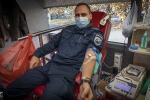 policjant podczas oddawania krwi w krwiobusie
