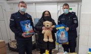 dwaj policjanci i pracownik schroniska podczas przekazania darów dla zwierząt