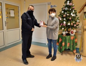 policjant przekazuje dary przedstawicielce hospicjum