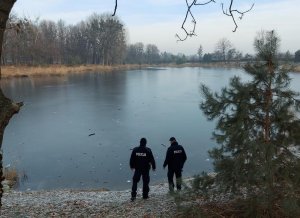 dwaj policjanci przy brzegu zbiornika wodnego