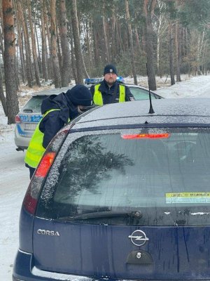 Policjanci podczas kontroli drogowe. Pora dzienna okres zimowy widoczny wokół śnieg
