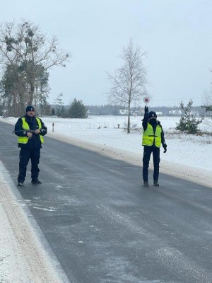 Policjanci ruchu drogowego zatrzymują pojazd. Po raz dzienna okres zimowy widoczny na polach śnieg droga sucha
