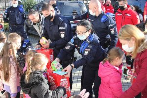 polscy policjanci rozdają kosowskim dzieciom zestawy słodyczy i przybory szkolne
