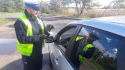 umundurowany policjant ruchu drogowego kontroluje kierowcę auta