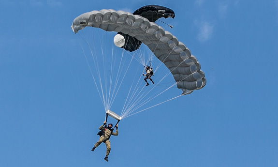 Dwaj spadachroniarze na tle błękitnego nieba.
