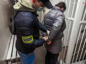 policjant zakłada kajdanki zatrzymanej kobiecie