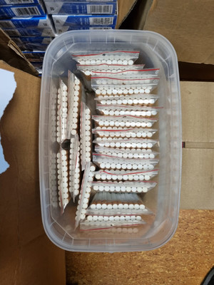papierosy w foliowych woreczkach umieszczone w plastikowym pojemniku