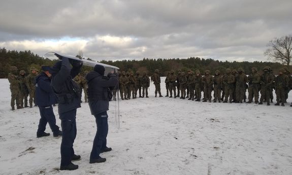 Policjanci szkolą żołnierzy na zaśnieżonym polu