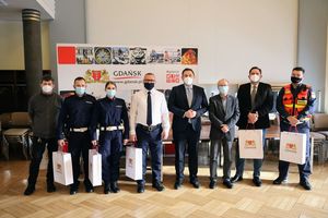 Siedem osób pozuje do zdjęcia wraz z Zastępcą Prezydenta Gdańska, wśród nich dwoje umundurowanych policjantów