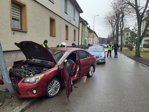 policjanci stoją przy rozbitym samochodzie