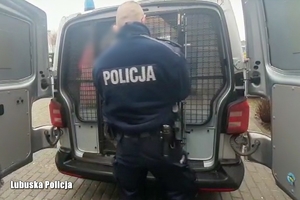 Policjant zamyka zamek w samochodzie po obsadzeniu zatrzymanego