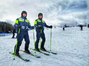 dwóch umundurowanych policjantów na stoku narciarskim