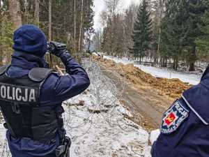 umundurowani policjanci zabezpieczają budowę zapory na granicy z Białorusią, patrolują i obserwują rejon oraz dbają o bezpieczeństwo osób wykonujących prace budowlane na granicy.