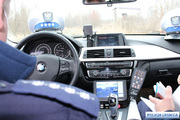 Wnętrze policyjnego radiowozu i widok na kierownicę i przednią szybę auta