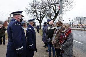 Komendant Główny Policji i Komendant Stołeczny Policji stoją przed trzema kobietami - rodziną tragicznie zmarłego policjanta  - widok z boku