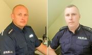 Dwaj umundurowani policjanci siedzący przy biurku