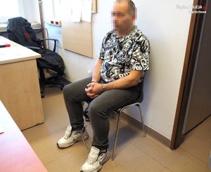 zatrzymany mężczyzna w kajdankach siedzi na krześle