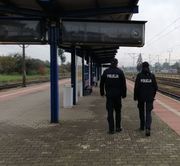 umundurowani policjanci idą wzdłuż torów kolejowych
