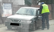 policjant stoi przy samochodzie osobowym