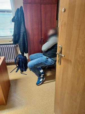 mężczyzna zatrzymany przez policjantów siedzący na krześle w pokoju