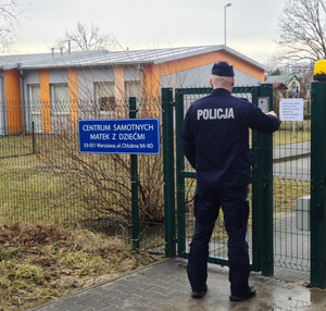 policjant przed furtką Ośrodka Wsparcia dla Kobiet z Dziećmi i Kobiet w ciąży – „Etezja”, w Warszawie