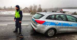umundurowany policjant na granicy polsko-białoruskiej stoi obok radiowozu