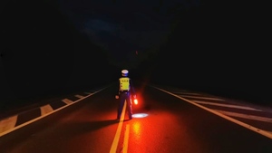 policjant nocą na drodze z latarką