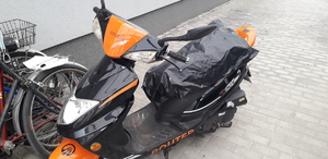 Zdjęcie kolorowe. Czarny skuter z pomarańczowymi elementami