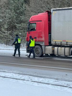 dwaj policjanci przy zatrzymanym samochodzie ciężarowym