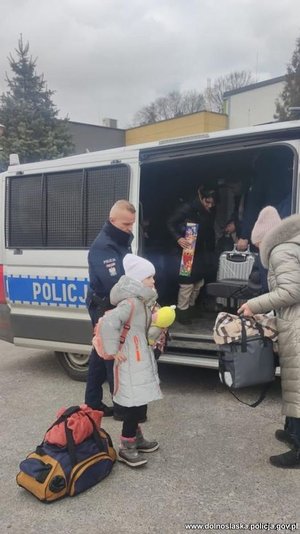 Policjanci pomagają uchodźcom na granicy