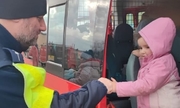 policjant pomaga dziecku wysiąść z busa