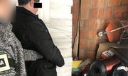 Sprawca kradzieży szpul z nawiniętym drutem miedzianym trzymany przez policjanta